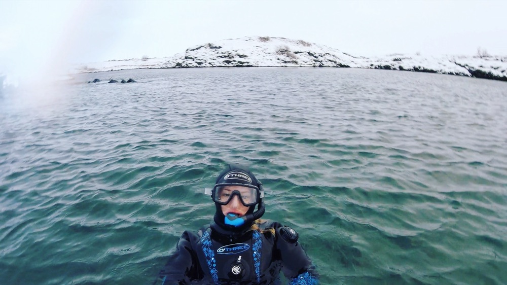 Beth in a drysuit and mask, snorkeling the Silfra fissure in Iceland