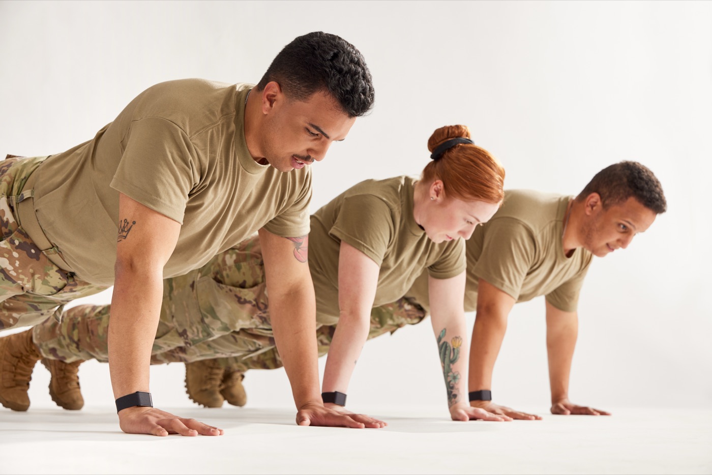 A military team doing push-ups in formation, wearing WHOOP straps