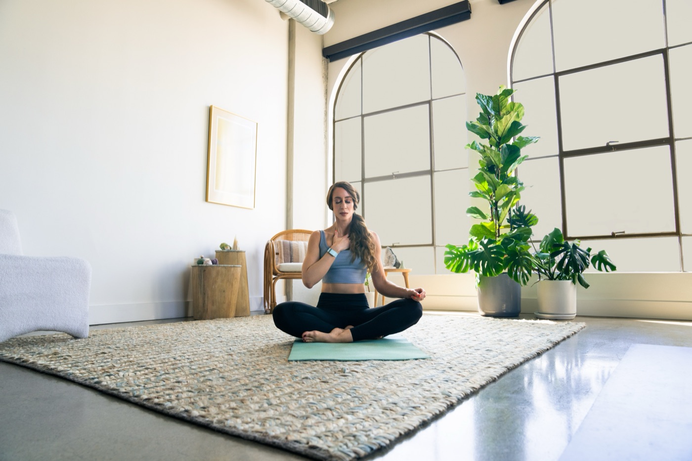 A WHOOP member sitting cross-legged in a calm, sunlit room
